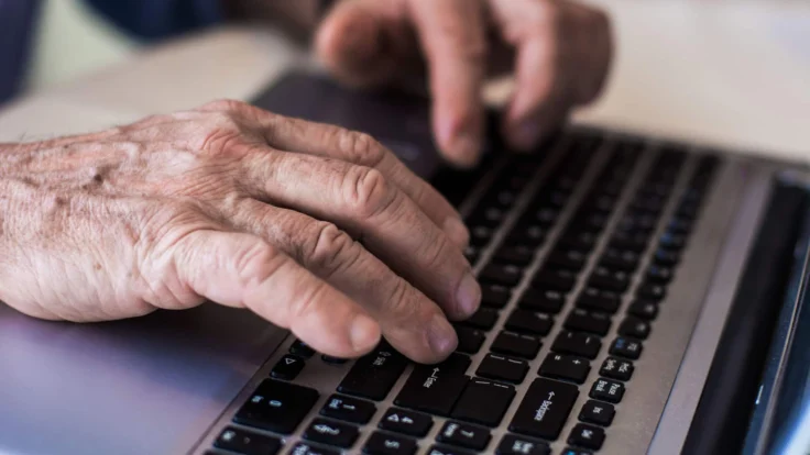 mani di una persona adulta che scrivono al computer