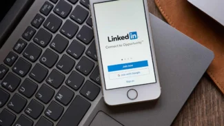 smartphone con la schermata di accesso a linkedin appoggiato su portatile